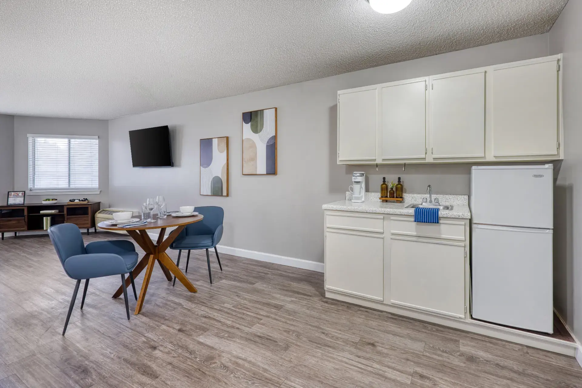 Dining table with furnished kitchen and living room.