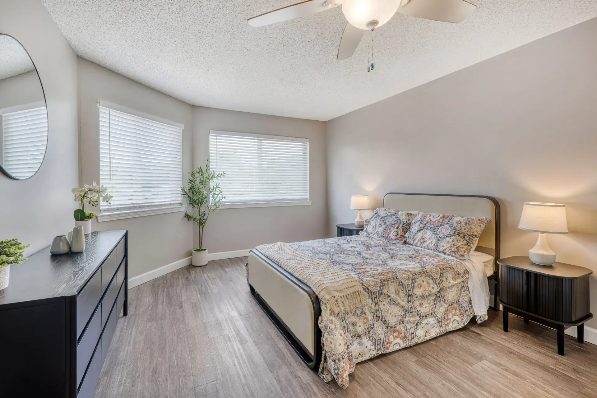 Fully furnished bedroom with plants and floral decor.
