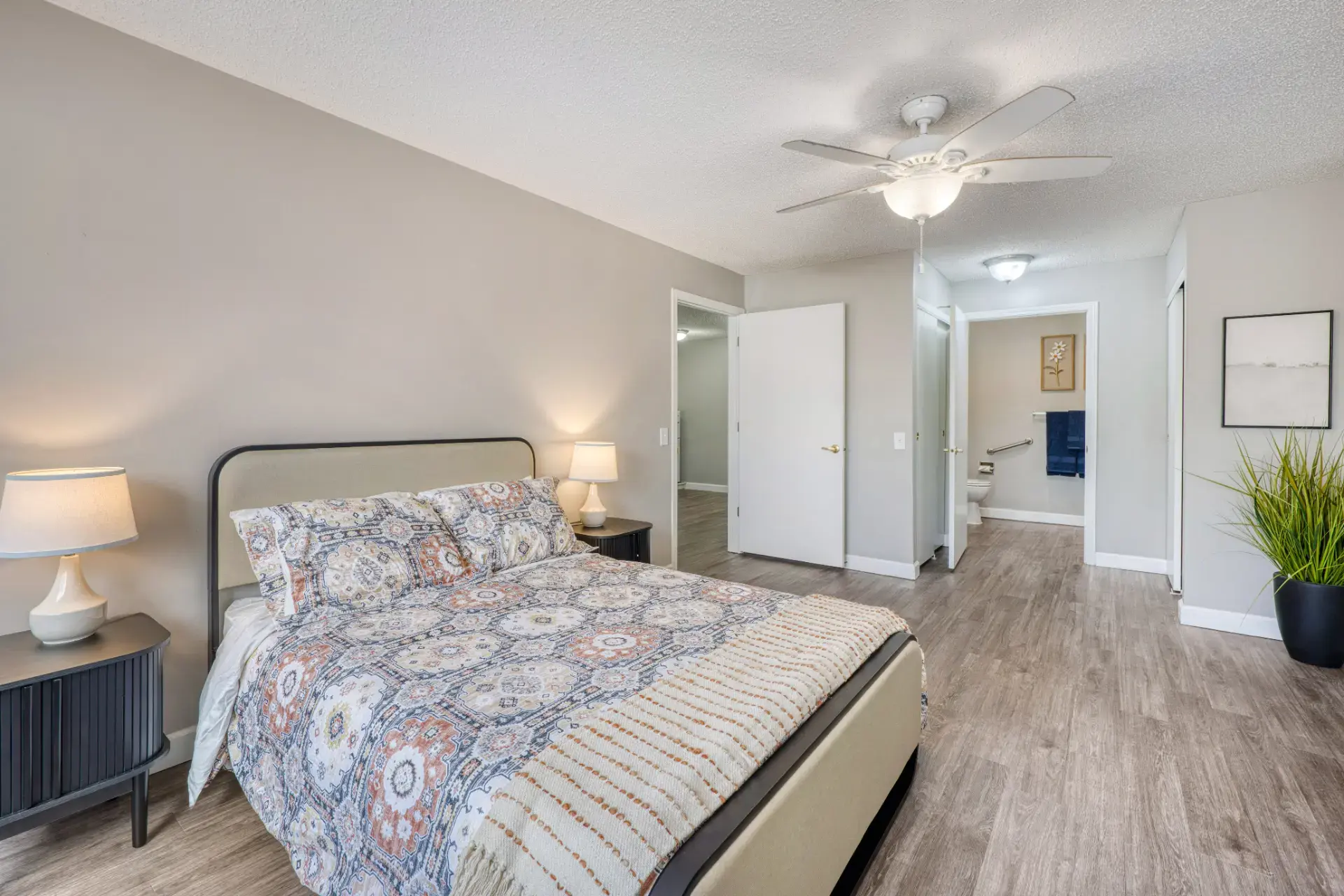 Furnished bedroom with lighting and floral decor.